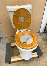 Wooden toilet seat with an ear in the middle, on a toilet