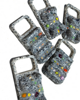 Multiple gray speckled phone cases with colorful gemstones on a white background