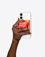 Hand holding a smartphone with a colorful case on a white background