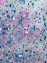 Speckled pattern with blue, pink, and white colors on a textured background