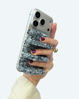 Hand holding a phone with a glittery case against a white background