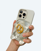 MagSafe accessory with a pretzel design on a phone  held by a hand on a white background