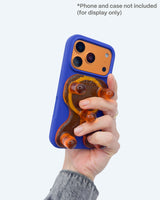 Hand holding a phone with a blue case featuring a dog design on a white background