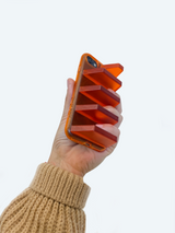 hand holding orange phone case as a grip to better hold phone